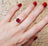 Square-cut ruby ring with matching red nail polish in ethical mining article.