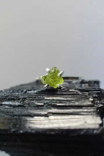 Raw Peridot crystal on dark mineral, perfect for an August birthstone collection.