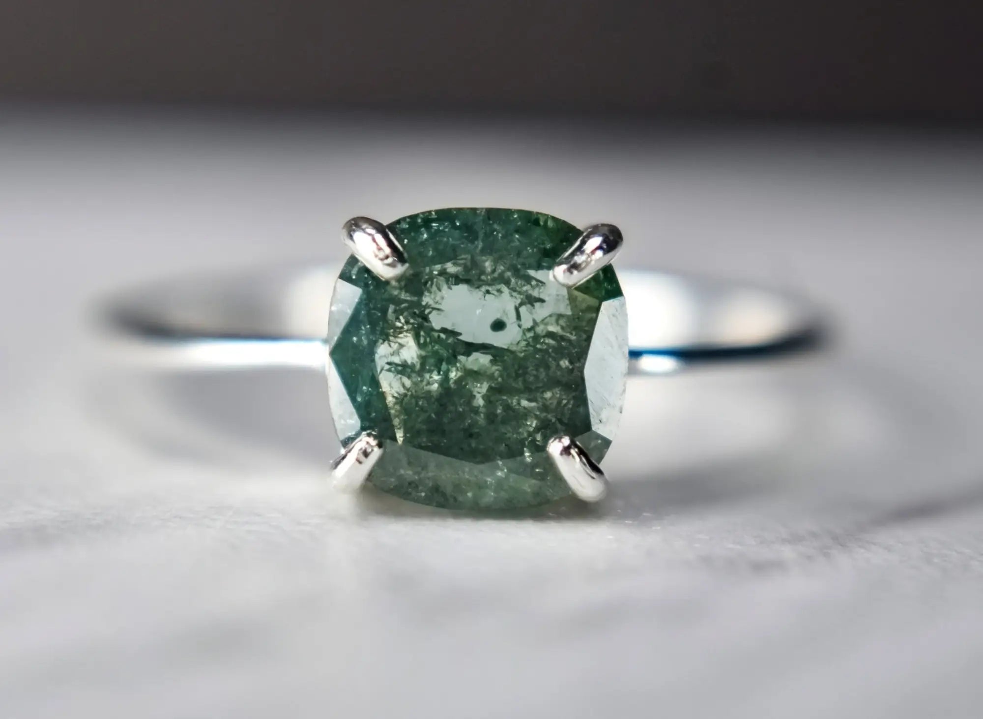 Silver ring with cushion-cut green gemstone, a stunning durable gemstone for April birthstone.