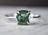 Silver ring with cushion-cut green gemstone, a stunning durable gemstone for April birthstone.