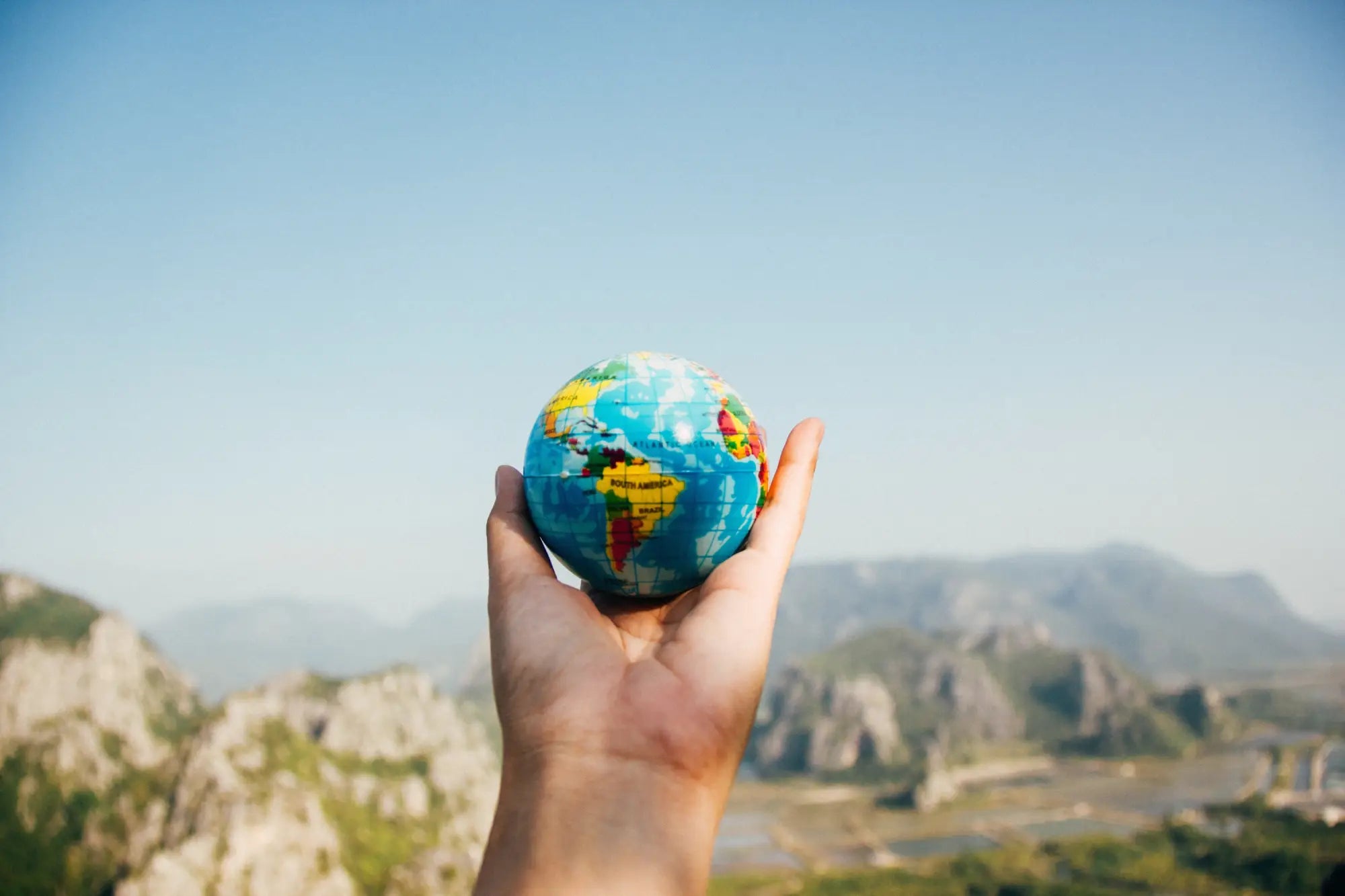 A hand holding a globe symbolizes Earth Day’s fight against global warming.
