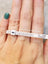 Ring sizer measuring tape around a finger with teal nail polish for mini orders.