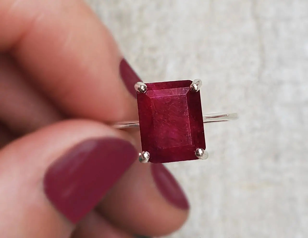 Ruby gemstone ring featuring an emerald-cut stone in silver, highlighting July birthstone.