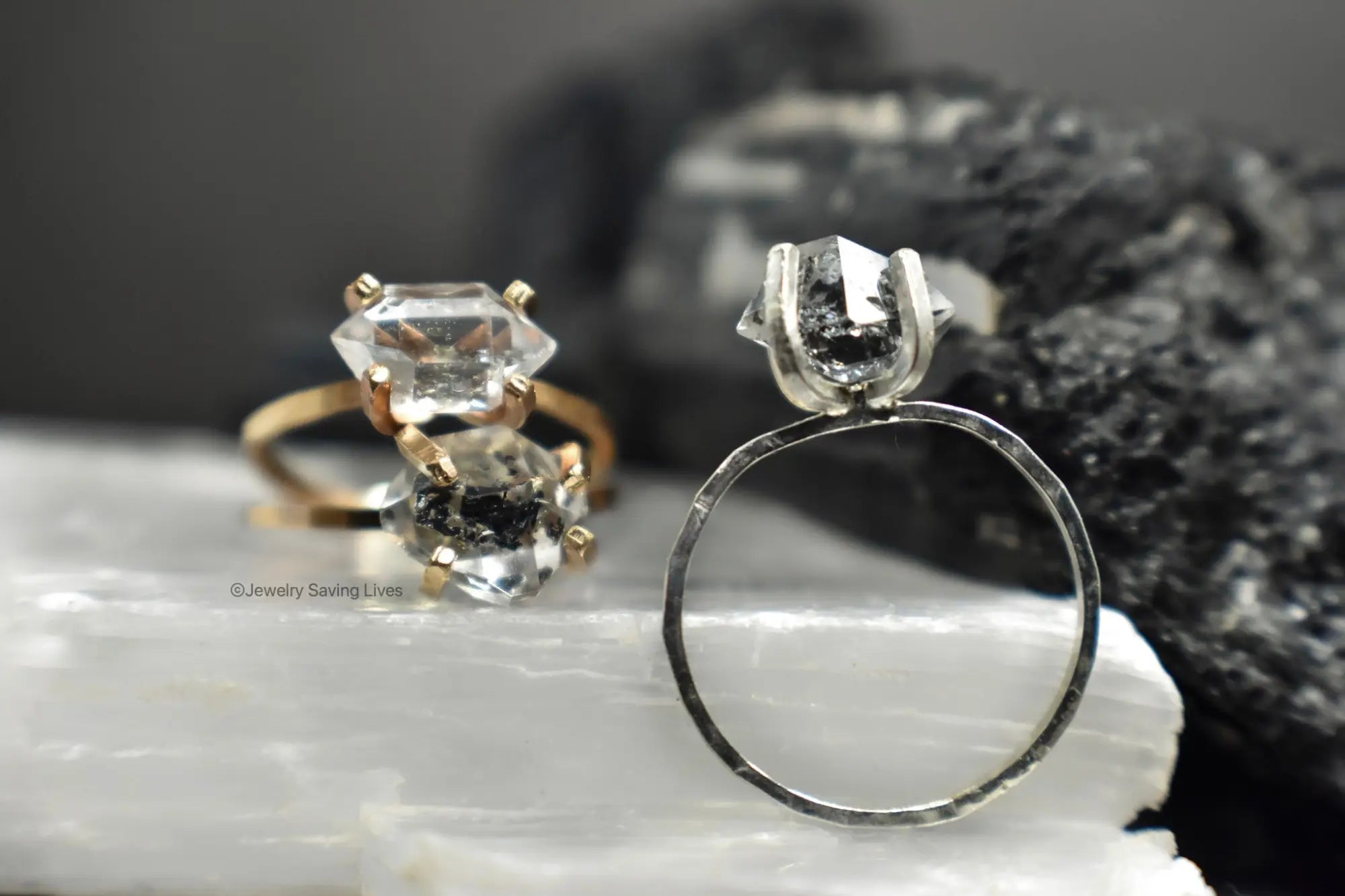 Two engagement rings with clear Herkimer diamonds in gold and silver prong settings.