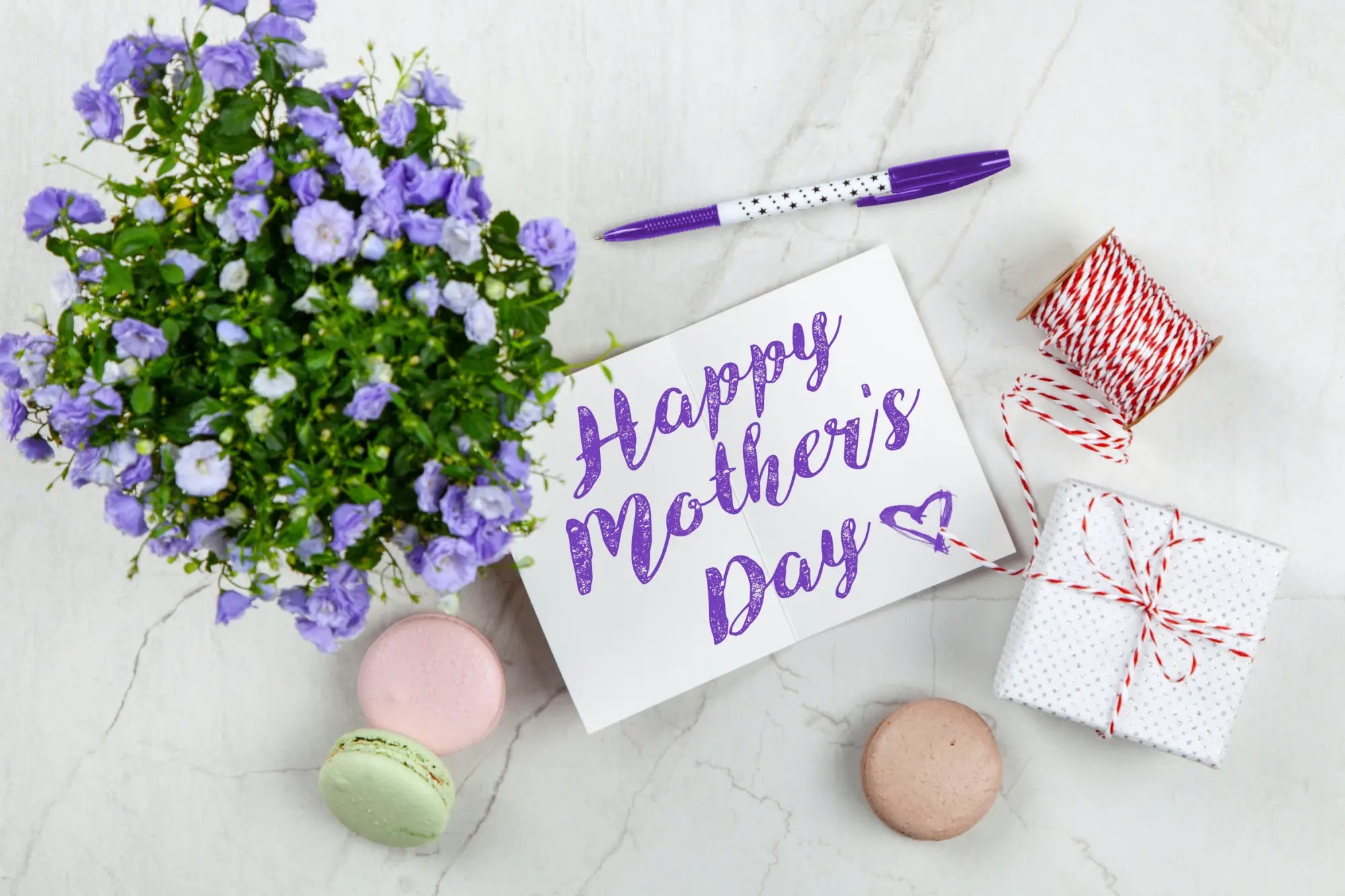 Happy Mother’s Day message in purple calligraphy on white paper with natural tanzanite.