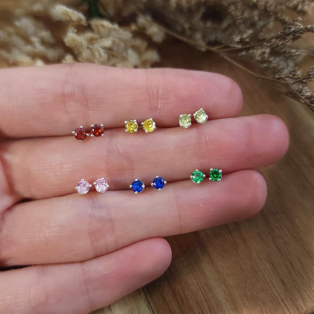 Colorful 3mm stud earrings arranged on a palm for stylish jewelry display