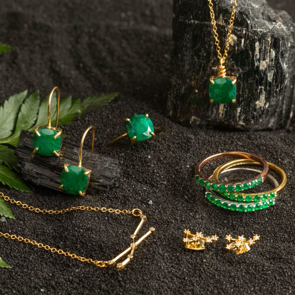 Elegant gold jewelry set with emerald green gemstones for an Emerald Half Eternity Band