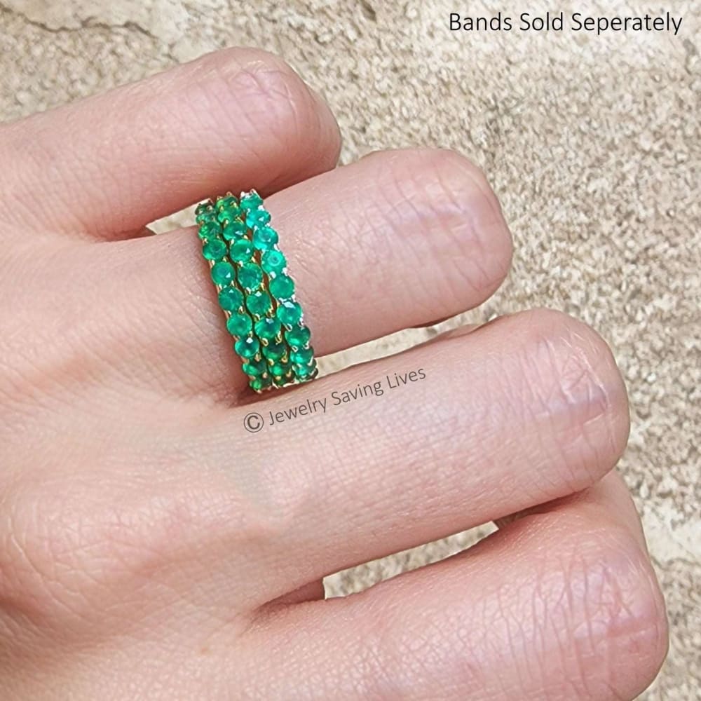 Bright emerald green half eternity band featuring multiple rows of gemstones