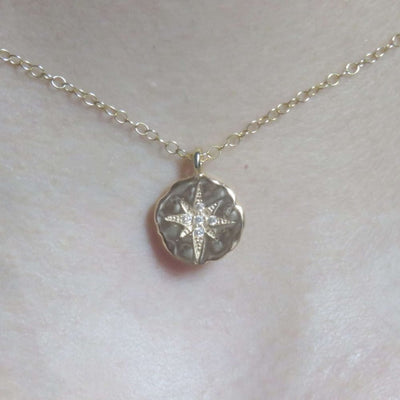 Silver celestial coin necklace featuring a crystal-studded star pendant on a delicate chain