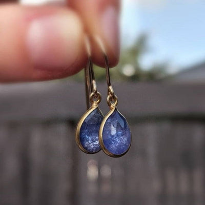 Natural teardrop tanzanite earrings in gold settings, ethically sourced and elegant