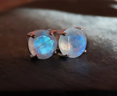 Pair of moonstone stud earrings with blue iridescent glow.