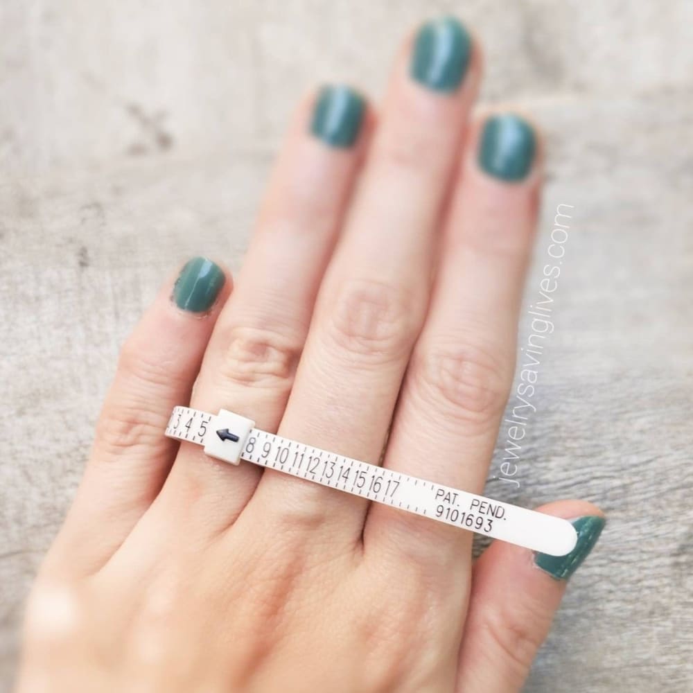 Plastic Ring Sizer measuring tape around a finger with teal nail polish for accurate sizing