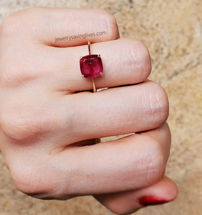 Rose gold ring featuring a cushion-cut ruby gemstone.