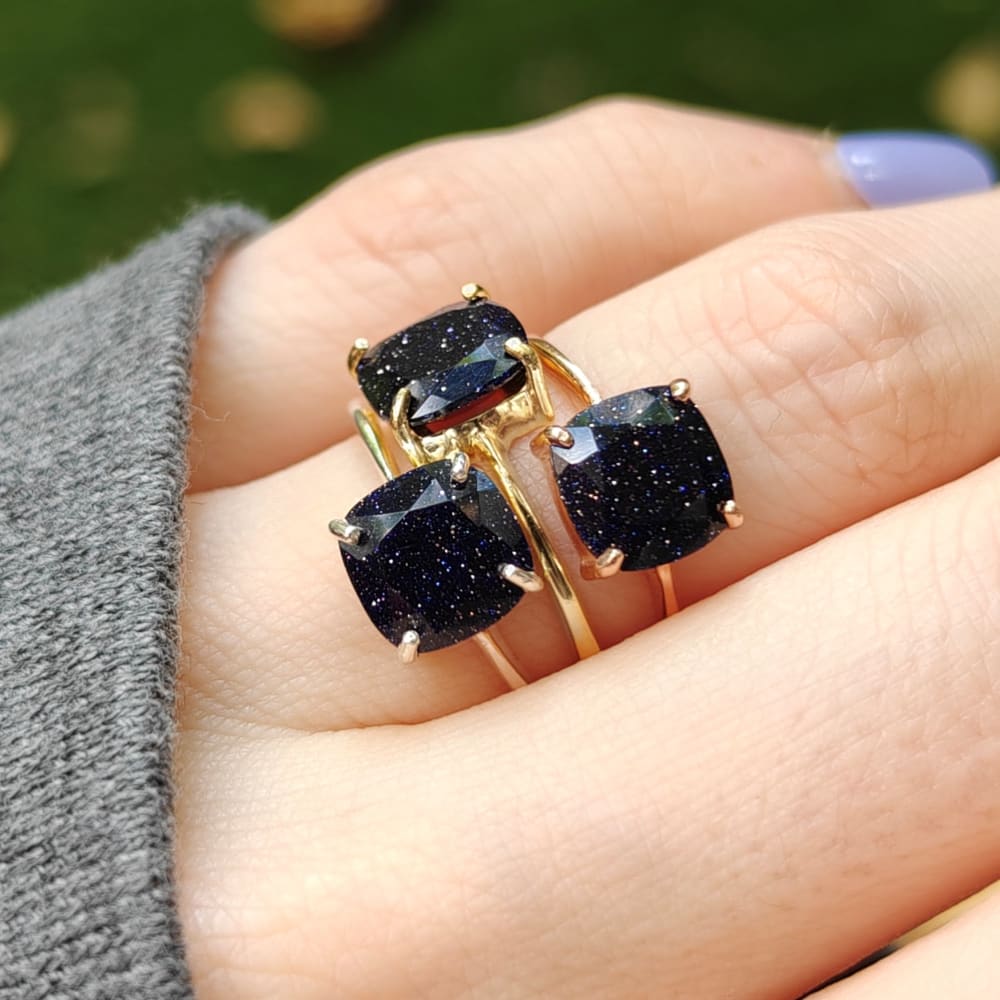 Gold rings adorned with dark blue sandstone gemstones from The Asher collection