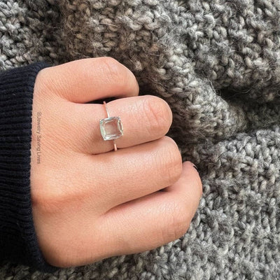 Silver ring featuring an 8x8mm natural aquamarine setting worn on a finger