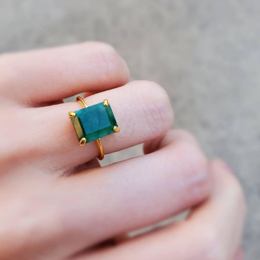 Gold ring with an emerald-cut natural emerald in a elegant prong setting