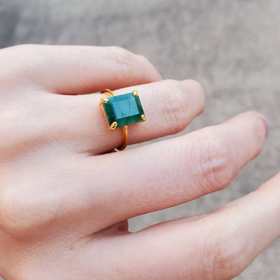 Gold natural emerald ring featuring a stunning emerald-cut blue-green gemstone