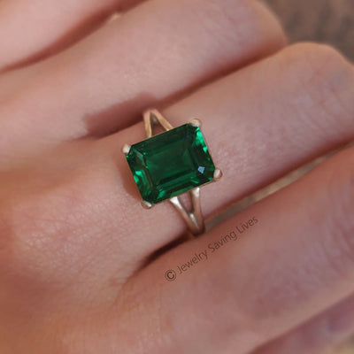 Emerald-cut green gemstone in The Audrina Emerald Ring with a gold band