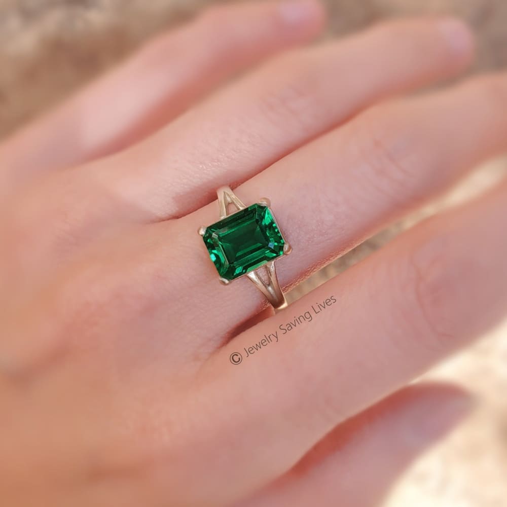 Emerald-cut green gemstone ring in gold featuring The Audrina Emerald Ring design