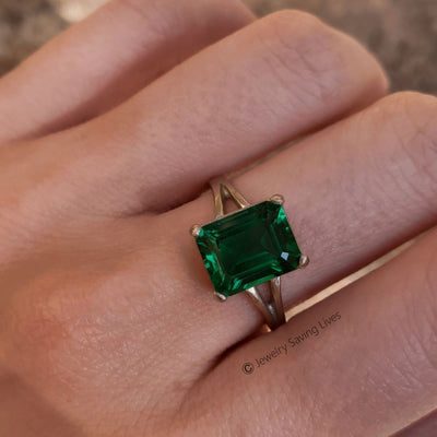 Emerald-cut green gemstone in gold, showcasing The Audrina Emerald Ring design